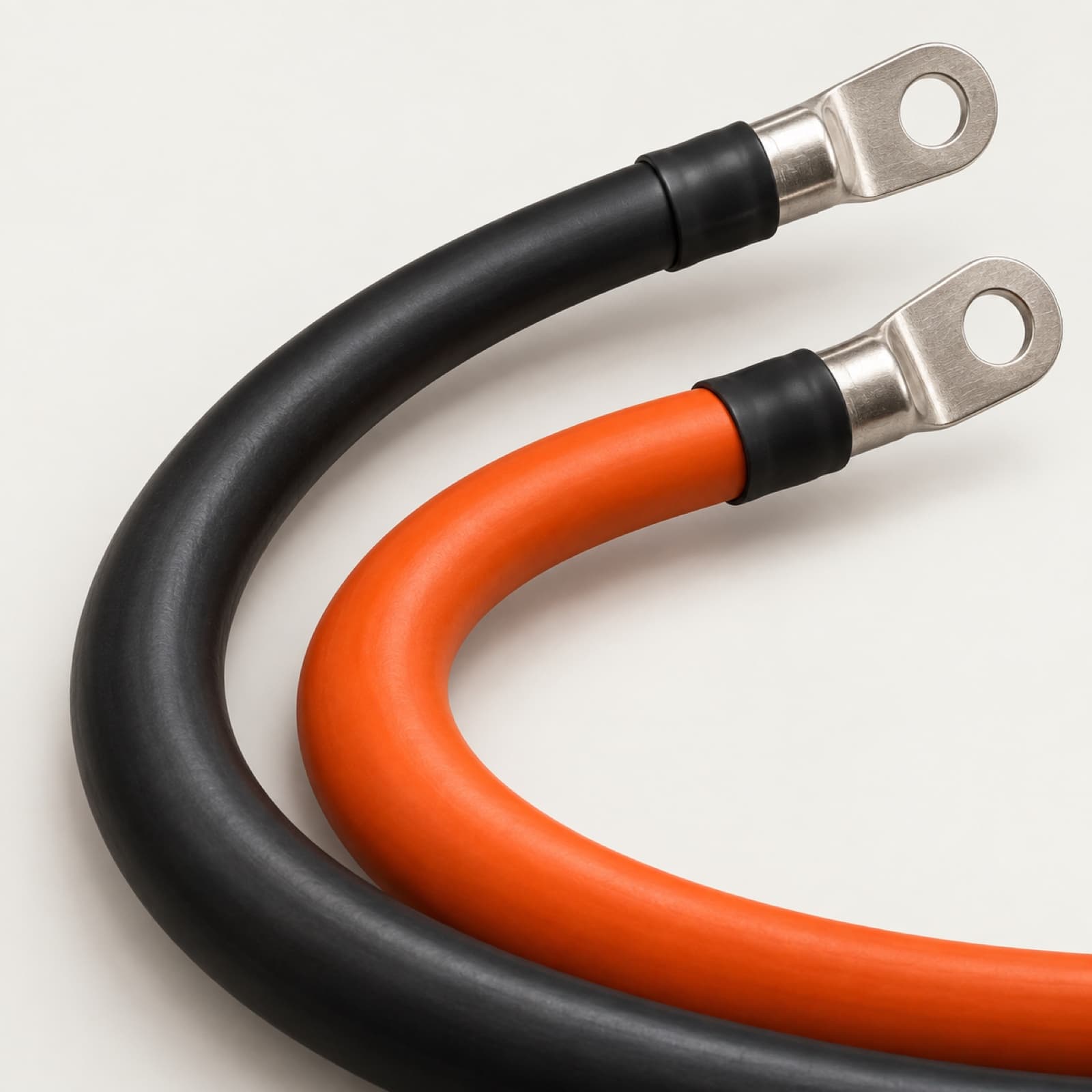Detail eines schwarzen und eines orangenen Kabels mit metallischen Ringkabelschuhen