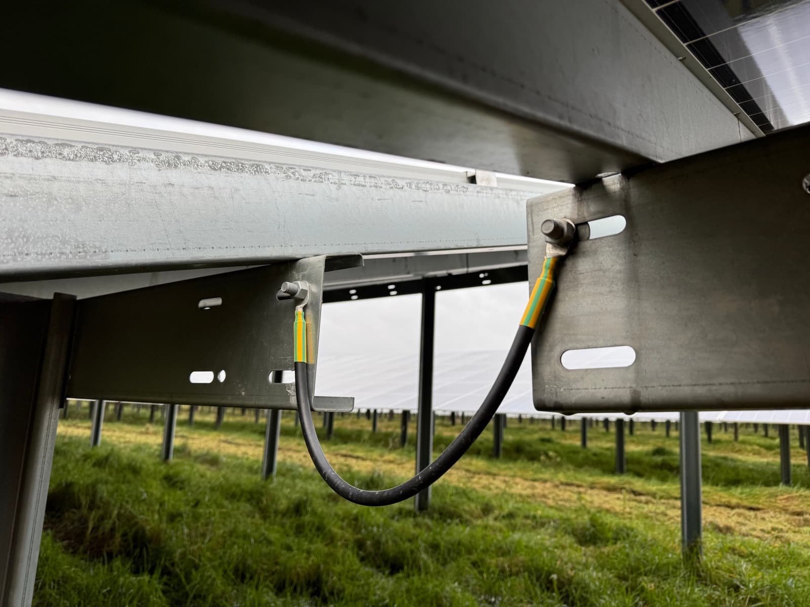 Potentialausgleichskabel mit M12-Rohrkabelschuhen, montiert an der Unterkonstruktion eines PV-Modultisches